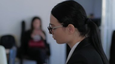 Gözlüklü, sinirleri bozuk bir iş kadını ofiste aklına yakın plan bir fikir gelir.
