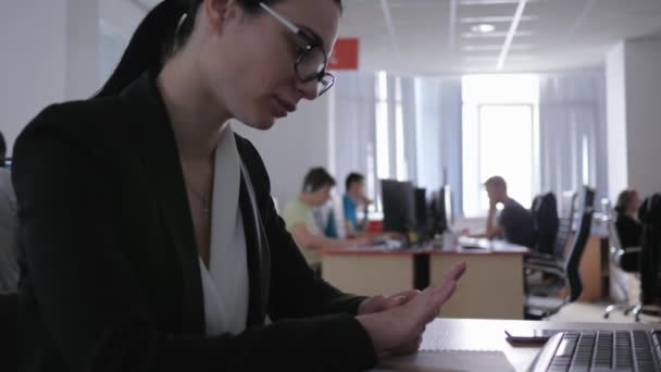 Oninteressant werk, depressief aantrekkelijk meisje in bril kijkt naar zichzelf zitten aan tafel — Stockvideo