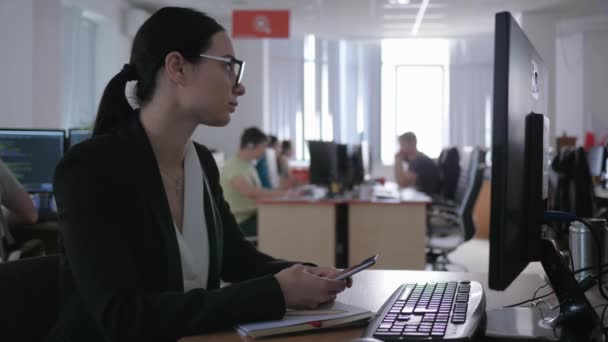 Escritório, menina de negócios cansado com óculos usa gadget e pensa em algo enquanto trabalha close-up — Vídeo de Stock