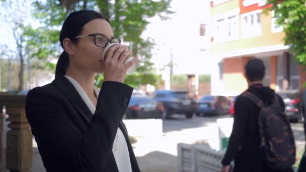 Lider av depression, allvarlig affärskvinna dricka kaffe och håller modern smartphone på urban street — Stockvideo