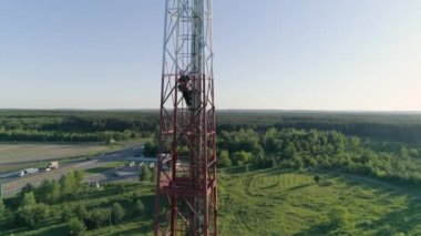 Üniformalı ve kasklı bakım personeli tehlikeli yüksek irtifa işlerinde merdivenleri tırmanır.