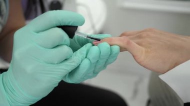 Tırnak tasarımı, manikürcü kolları ve güzellik salonunda oje yaparken kız.