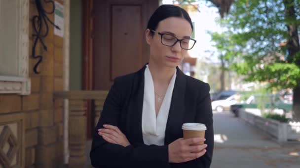 Стрес у житті, молода бізнес-леді в окулярах страждає від депресії і гуляє по міських вулицях з кавою в руках — стокове відео