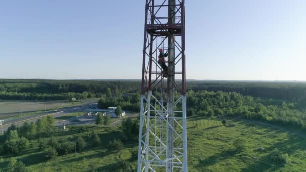 Technician worker servicing cellular antenna man dressed in uniform and helmet climbs the stairs on dangerous work — Stock Video