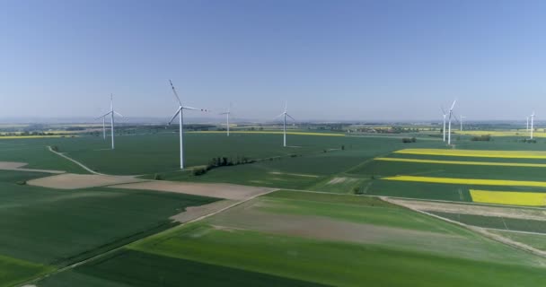 Воздушная съемка полей с различными видами сельского хозяйства с ветряными мельницами вблизи сельской местности — стоковое видео