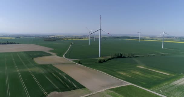 Сельская местность с ветряными турбинами и сельскохозяйственными полями, вид с воздуха — стоковое видео