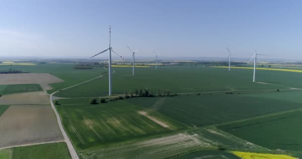 Moderne windturbines die duurzame energie opwekken op het veld met gewas, luchtfoto — Stockvideo