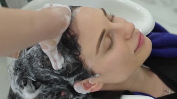 Frisörsalong, frisör tvättar med professionell schampo hår av nöjd kvinna i skönhet Studio — Stockvideo