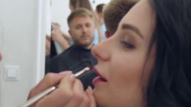 Barvy na rty, atraktivní muž se dívá na proces make-up ženy v salonu krásy — Stock video