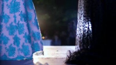 Parlak spot ışıklarıyla podyumda şık, uzun gece elbisesiyle mankenleri kirletiyor.