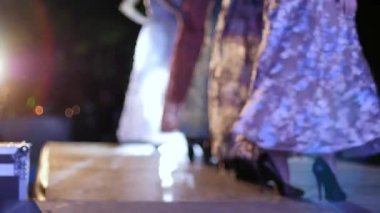 Tasarımcı elbiselerinin sunumu, gece elbisesi giymiş mankenler podyumda moda gösterisi yapıyor.