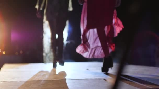 ドレスショー、デザイナーのガウンのファッションプロファイルモデル上の高いヒールの上にキャットウォークで照明 — ストック動画