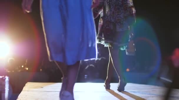 ファッション、表彰台の女の子がデザイナーの服やハンドバッグに手でスポットライトの照明でキャットウォークに沿って歩く — ストック動画