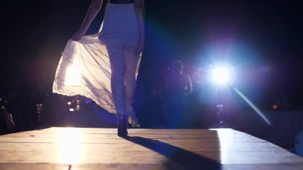 Desfile de moda, modelo femenino en vestido elegante y zapatos de tacón alto va por la pasarela en el evento nocturno — Vídeos de Stock