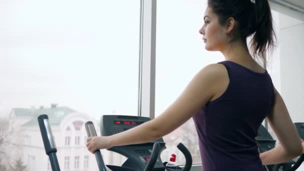 Bela menina fitness se exercitando no simulador no ginásio — Vídeo de Stock