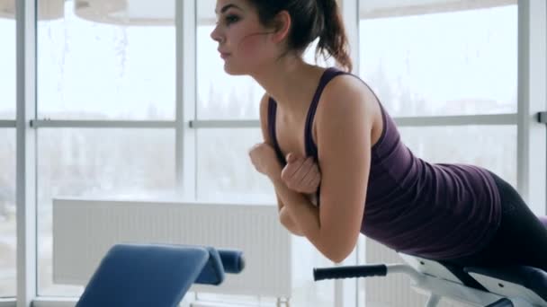 Fitness femenina de prensa basculante en el club deportivo con grandes ventanas — Vídeos de Stock