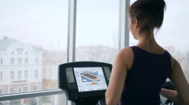 Vücut çalışmalar, güzel bir kadın spor salonunda çalışırken çalışan simülatörde soğuk su içiyor.