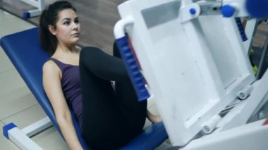 Sporcu güçlü kız platform bacağını kaldırıyor ve spor kulübünde baş parmağını kaldırıyor.