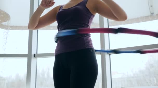 朝体操女性はフィットネスクラブの腰に円を描く — ストック動画