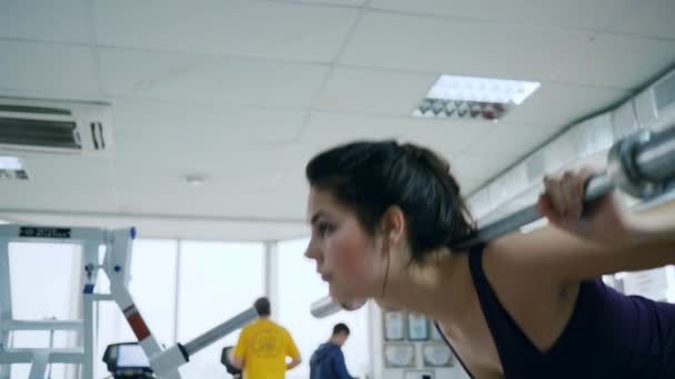 Entrenamiento de fuerza, la mujer realiza ejercicio con barra en los hombros en el complejo deportivo — Vídeo de stock