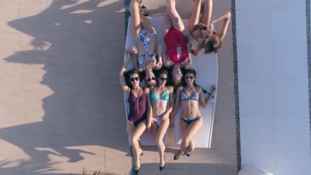 Sommerurlaub, junge Frauen in Brille und Badeanzug stehen abwechselnd auf Liegen im Freien auf — Stockvideo