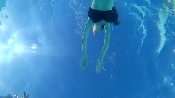 Women with beautiful body into Swimsuit floating in clear water at pool in solar lighting, underwater bottom view — Stock Video