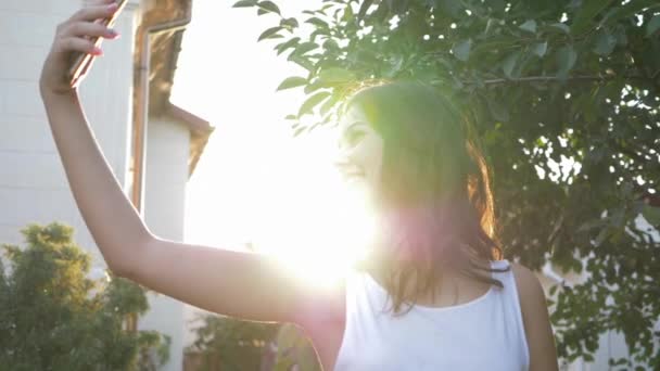 Mujeres atractivas felices haciendo foto en el teléfono inteligente en la luz del sol brillante en la naturaleza — Vídeos de Stock