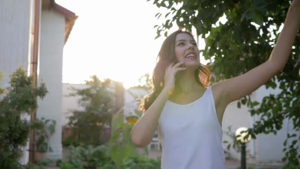 Mobil kapcsolat, csinos lány beszél okostelefon és élvezi a természet napfényben — Stock videók