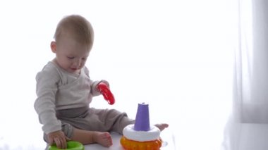 Tatlı çocuk parlak odada eğitici oyuncaklar piramidi oynadı.