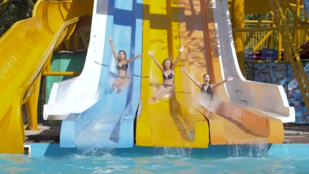 Waterpark, jonge vrouw rolt op waterglijbaan en in Zwembad met Splashing op vakantie — Stockvideo