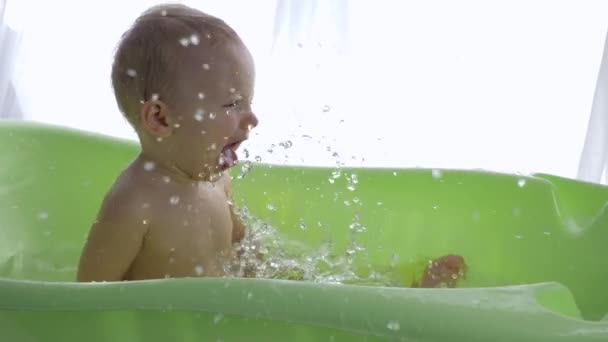 Higiene de los niños, niño alegre tomar placer salpicaduras de agua mientras toma el baño — Vídeos de Stock