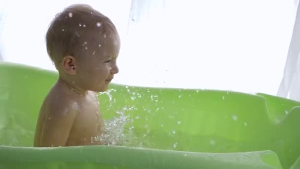 Menino feliz desfrutar salpicando água enquanto toma banho — Vídeo de Stock