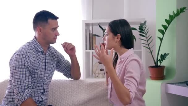 Сімейні проблеми, агресивна дружина свариться з чоловіком і розлюченими жестами рук під час суперечки в кімнаті — стокове відео