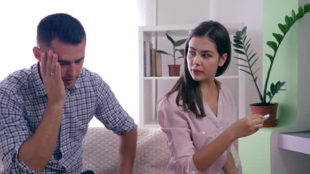 Social issues in family, expectant woman with Man with positive pregnancy test unhappy by results in bright indoors — Stock Video