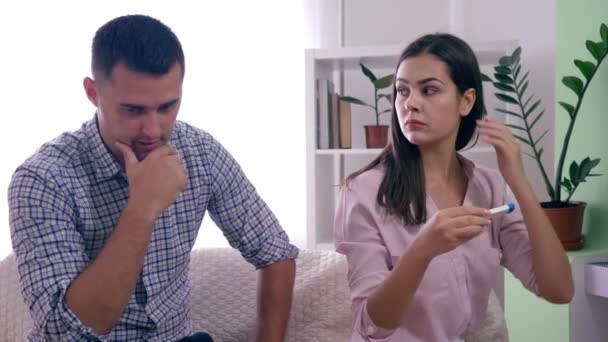 Problemas sociales en la familia, la maternidad esposa con el marido con positivo prueba de embarazo furioso por los resultados en la habitación luminosa — Vídeo de stock