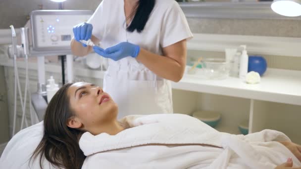 Kosmetik aplikuje speciální krém s omlazením Účinek na tvář klientky v salonu krásy v ošetřovně