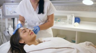 Spa salonu prosedürleri, tedavi odasındaki güzellik salonunda kozmetik tedavi gören genç bir kadın hasta.