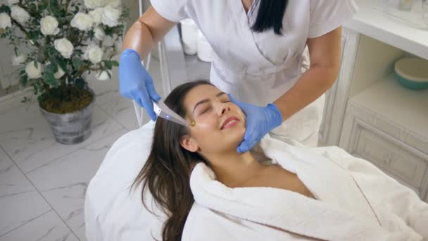 Menina paciente feliz em procedimentos de cuidados da pele com a ajuda de pressão de oxigênio pulsante na sala de tratamento no salão de beleza — Vídeo de Stock