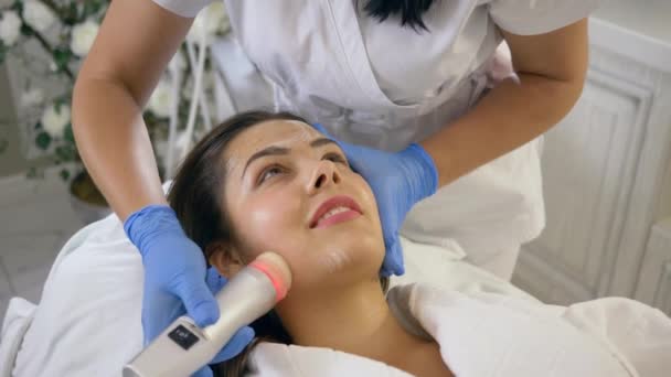 Limpieza de la piel, divertido paciente femenino tomar placer cosméticos procedimientos rejuvenecedores en clínica de belleza — Vídeos de Stock