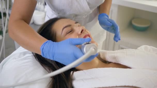 Tratamiento de la piel, mujer cliente contento tomar placer rejuvenecer los procedimientos cosméticos de limpieza de la piel facial en el salón de spa — Vídeos de Stock