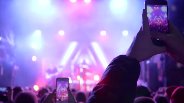 Rockvakantie, menigte van mensen met mobiele telefoon gefotografeerd muziekartiesten op het podium — Stockvideo