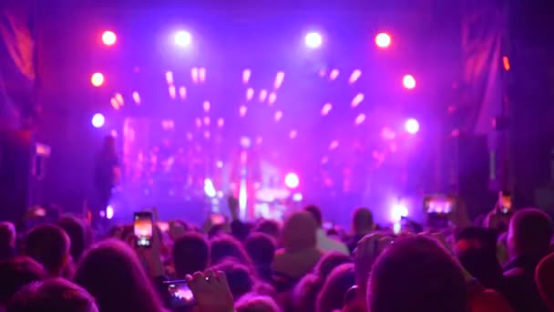 Rock art, persoon registreert concert op mobiele telefoon in heldere verlichting 's nachts — Stockvideo