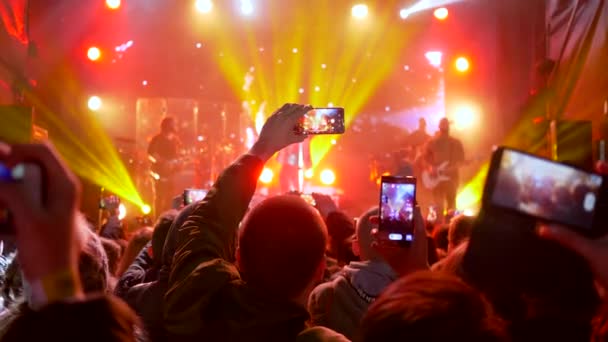 Rocková hudební událost s blikající světelnou show a kapelou na jevišti ve světle — Stock video
