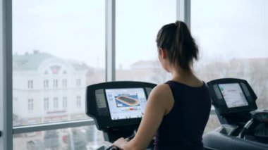 Spor Kompleksi, kız pencerenin arka planında spor salonunda dokunmatik ekran simülatörü kipini ayarlar