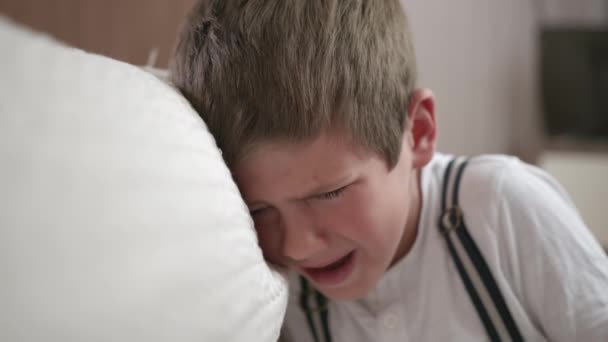 Föräldraskap, nyckfull hane barn hysterisk och gråter på grund av tjänstefel eller straff sitter i rummet nära soffa — Stockvideo