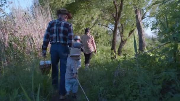 Сімейна прогулянка, щаслива дружня сім'я люблячих бабусь і дідусів зі своїми дорогими онуками веселяться прогулянки на відкритому повітрі серед дерев — стокове відео