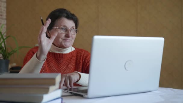 Anciana moderna, anciana bonita mujer se somete a entrenamiento en línea uso de videollamadas en el ordenador portátil — Vídeos de Stock
