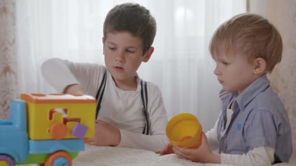 Feliz infancia, niños hermanos que se divierten desarrollando su pensamiento creativo jugando con juguetes de color platónico de seguridad — Vídeo de stock