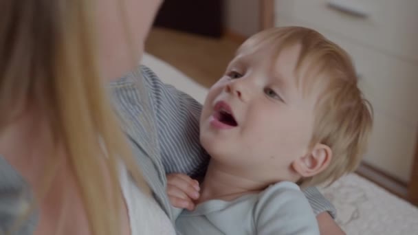 Menino bonito desfrutando de umas férias com sua mãe amorosa nos braços antes de dormir — Vídeo de Stock