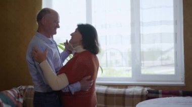 Yaşlı çiftler, romantik orta yaşlı büyükanneler ve büyükbabalar evde dans ederken birlikte rahatlıyorlar.